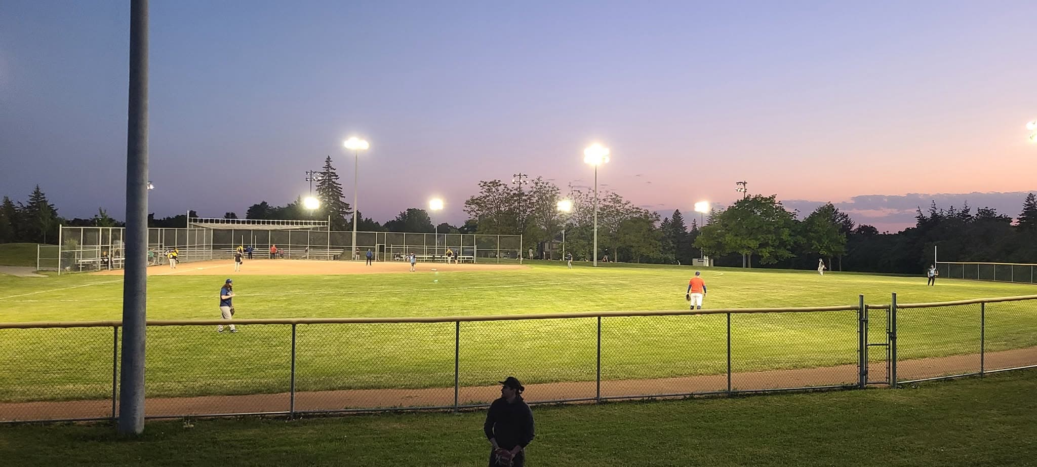 Slo-pitch game at dusk at an MMSPL ballpark